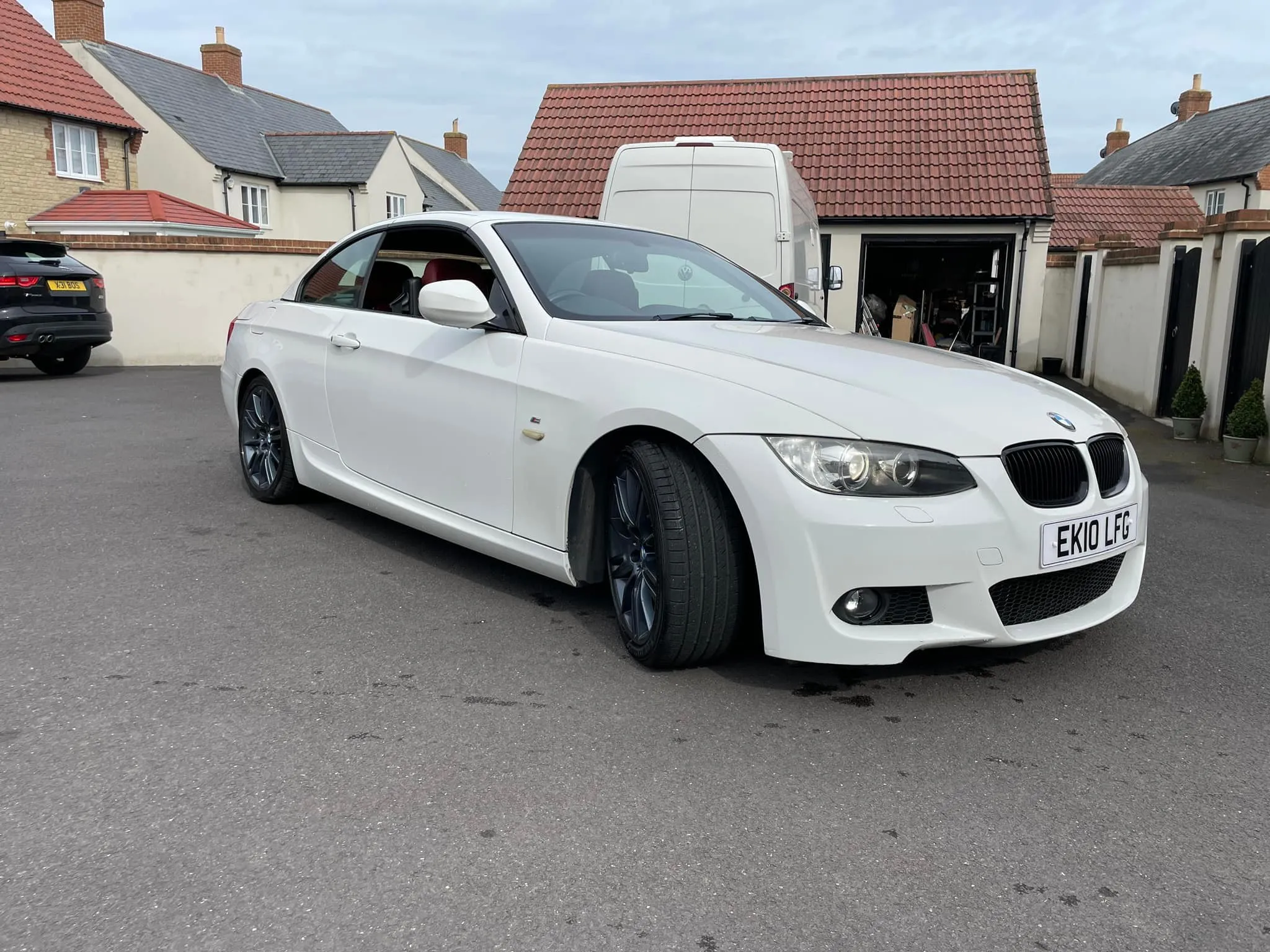 A white car parked in front of a house.