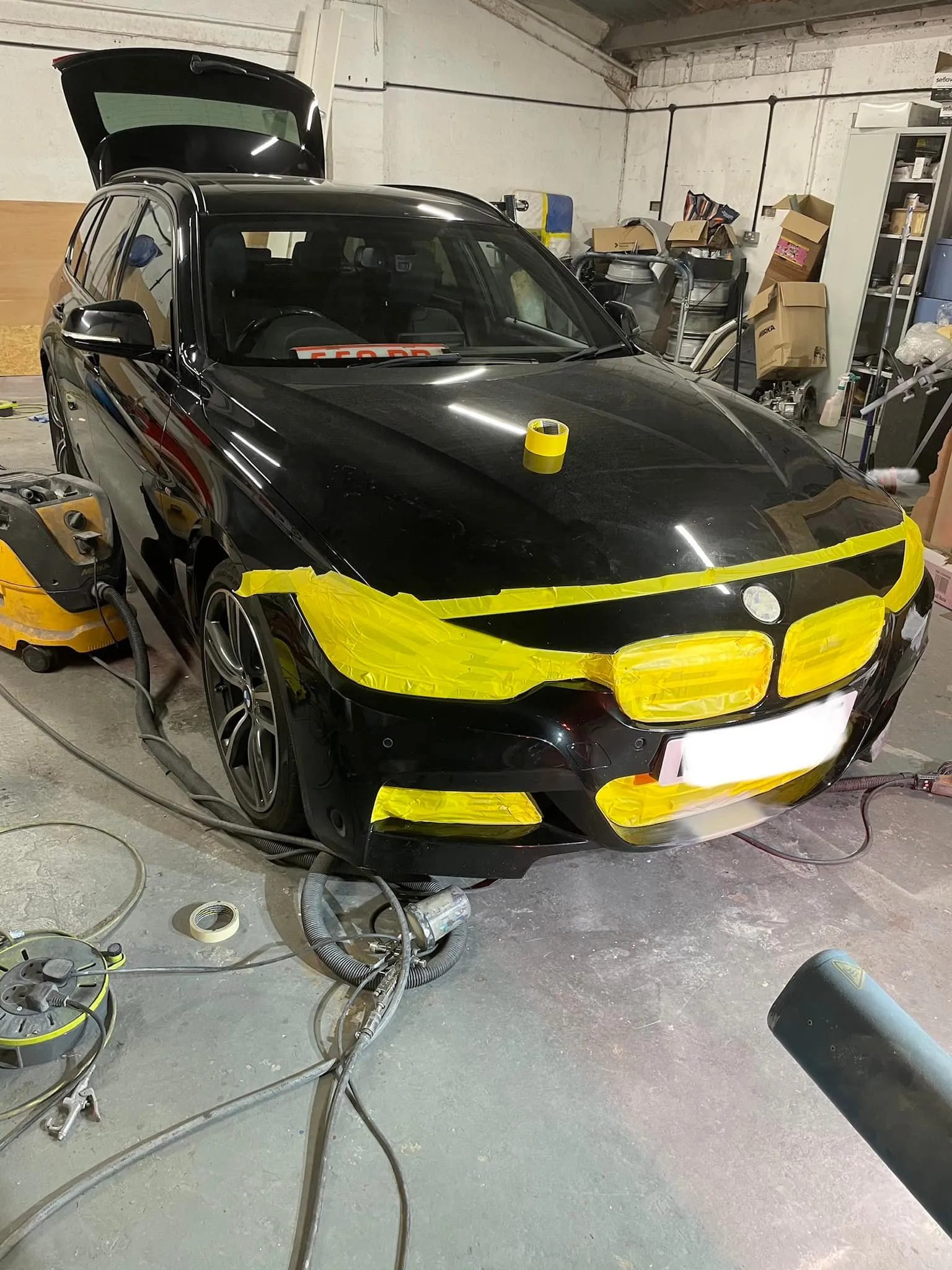 A car that is being worked on in a garage.