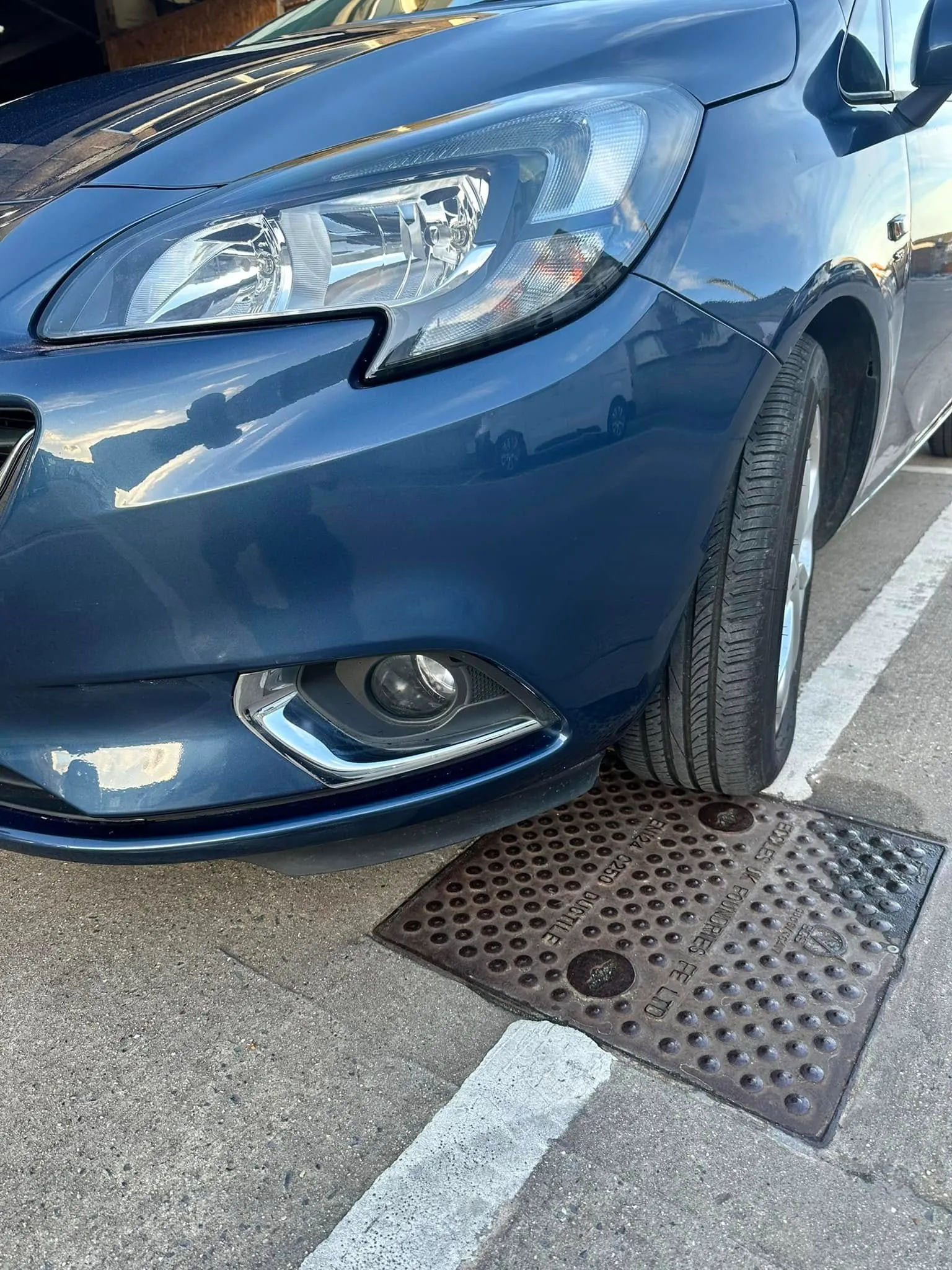 A blue car parked on the side of the road.